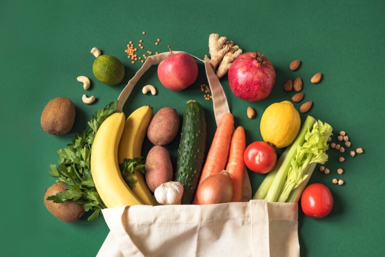 Delivery healthy food background. Vegan vegetarian food in eco bag vegetables and fruits, nuts and grains on white, copy space, banner.Grocery shopping food supermarket and clean eating concept.
